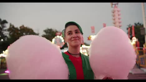 Und-Ein-Lesbisches-Mädchen-Mit-Kurzem-Grünem-Haarschnitt-In-Einem-Grünen-Hemd-Geht-In-Eine-Parka-Und-Trägt-Zwei-Riesige-Rosa-Zuckerwatte-In-Den-Händen