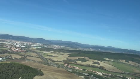 Aerial-panoramic-view-of-Pamplona-city,-in-Spain,-aS-seen-by-the-pilots-in-a-real-time-flight,-in-a-sunny-bright-morning