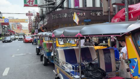 Tuk-tuks-parked-by-the-roadside-at-Yaowarat-Chinatown,-Bangkok,-Thailand