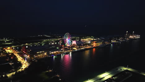 Aerial-view-around-the-colorful,-illuminated-Navy-pier,-nighttime-in-Chicago,-USA