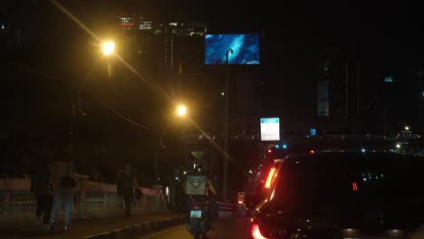 Vehicles-stopping-on-a-bridge-during-the-red-light-stop-in-Bangkok-along-Ratchada-Road-as-motorcycles-on-the-left-kept-going,-Bangkok,-Thailand