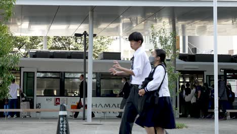 Commuters-Seen-Boarding-Tram-Outside-Kumanato-Station-On-Sunny-Afternoon-Day