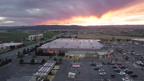 Costco-Parking-Lot-In-Montana-At-Sunset,-Aerial-Tracking-Shot
