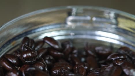 Kaffeebohnen-In-Einem-Behälter,-Der-Sich-Bewegt-Und-Den-Blick-Auf-Die-Röstung-Freigibt