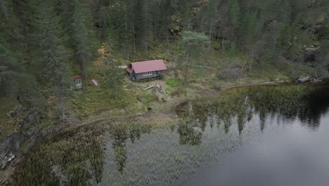 Hildremsvatnet,-Trondelag-County,-Norway---A-Lake-Embraced-by-Lush-Greenery,-and-a-Fisherman's-Cottage-Nestled-Along-the-Lakeshore---Aerial-Drone-Shot