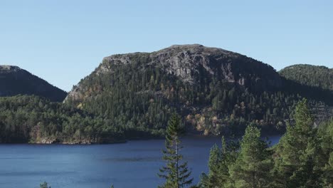 Hildremsvatnet,-Kreis-Trondelag,-Norwegen-–-Azurblaues-Wasser,-Umgeben-Von-üppigem-Grün,-Während-Eine-Ferne-Bergkette-Den-Horizont-Ziert-–-Luftschwenk-Nach-Links