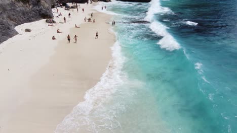 Holidaymaker-people-swimming-and-relaxing-on-sunny-diamond-beach,-Nusa-Penida