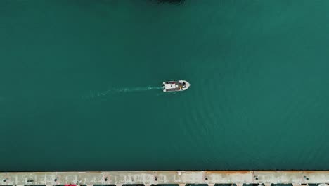Top-down-shot-of-a-small-scientific-boat-heading-out-to-conduct-research-in-Sete
