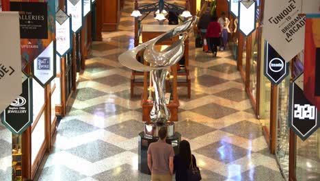 Turistas-Y-Compradores-Comprando-En-La-Icónica-Galería-De-Brisbane,-Galería-Comercial-En-Un-Edificio-Declarado-Patrimonio-De-La-Humanidad-Con-Una-Escultura-De-Espejismo-De-Gidon-Graetz-Como-Pieza-Central-En-El-Centro-Comercial-Queen-Street,-Ciudad-De-Brisbane