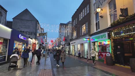 Timelapse-street-in-Cork-city,-Ireland-during-Christmas-time-with-decoration-and-lights-and-people-shopping