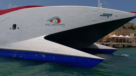 Toma-Panorámica-Aérea-Del-Ferry-Ponte-Ferries-Con-Dosel-Rojo-En-El-Puerto-De-Malta-Con-Vistas-A-Los-Edificios-Históricos-De-Valetta-En-Un-Día-De-Verano-De-Vacaciones