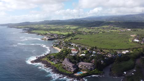 Stunning-panoramic-aerial-view-capturing-oceanfront-resort-hotels,-beach,-blue-ocean-and-mountain-landscape