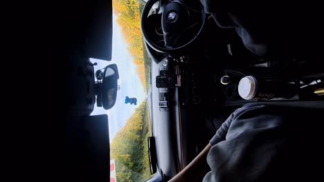 Viaje-Por-Carretera-Soleado:-Vídeo-Vertical-Desde-El-Asiento-Trasero-De-Un-BMW,-Conduciendo-Por-Una-Autopista-Entre-árboles-Otoñales,-Paradas-De-Café-Costa-Y-Navegación-En-Google-Maps