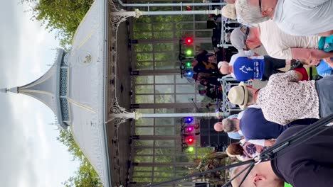 Harmonious-Gathering:-Vertical-Video-of-a-Live-Concert-in-Warrenpoint,-Northern-Ireland,-with-Seniors-Enjoying-Music-on-a-Cloudy-Day