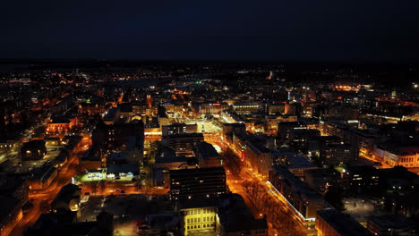 Drone-shot-circling-the-illuminated-downtown-of-Vaasa,-winter-night-in-Finland