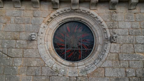 Drohnenaufnahme-Einer-Kirche-Mit-Heiligenskulptur-Und-Abgerundetem-Buntglasfenster
