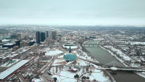 Establecimiento-De-Toma-De-Gran-Angular-Completo-Museo-Canadiense-De-Derechos-Humanos-Urbano-Winnipeg-Manitoba-Canadá-Centro-Rascacielos-Edificios-En-La-Ciudad-Paisaje-Nublado-Horizonte-Nevando-Invierno-Drone-4k-Tiro