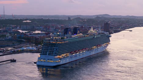 Drone-descends-showcasing-large-cruise-ship-in-Caribbean-port