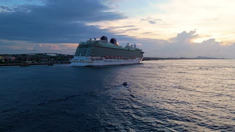 Drone-follows-skiff-with-small-wake-driving-out-to-Caribbean-cruise-ship-docked-at-port-town