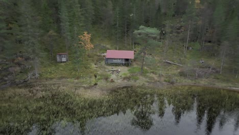 Pullback-Over-Wooden-Cottage-Isolated-In-The-Forest-Lake-Near-Hildremsvatnet,-Norway