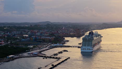 La-Luz-De-La-Hora-Dorada-Se-Extiende-Sobre-El-Agua-Del-Océano-En-Una-Cinematográfica-Ciudad-Portuaria-Del-Caribe-Con-Un-Crucero