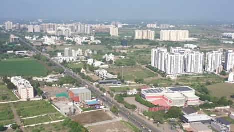 Vista-Aérea-De-La-Ciudad-De-Rajkot-Grandes-Edificios-Altos-Y-Bajos-Son-Visibles-En-La-Carretera-Kalavad