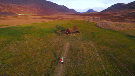 Drei-Touristen-Besuchen-Grafarkirkja,-Die-älteste-Kirche-Westislands,-Bei-Sonnenuntergang