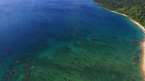 Panoramic-aerial-drone-shot-of-blue-ocean-coast-with-crystal-clear-azure-water