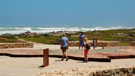 Turistas-Mirando-El-Mapa-Topográfico-De-África-En-El-Monumento-Del-Extremo-Sur-De-Agulhas