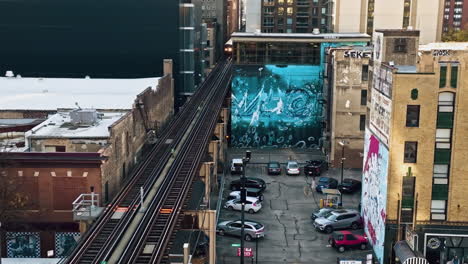 Aerial-view-rising-over-a-mural-and-train-at-the-Wabash-Arts-Corridor-in-Chicago,-USA