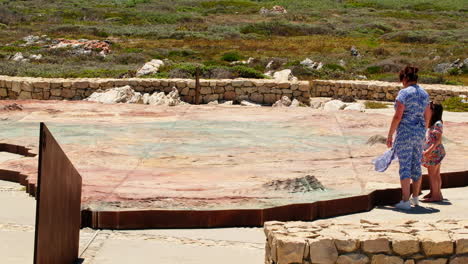 Mom-educates-kids-on-topographical-Africa-map-at-Southern-Tip-Monument,-Agulhas
