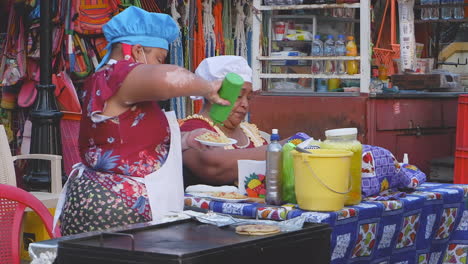 Dos-Mujeres-Ofrecen-Sabrosa-Comida-Callejera-En-Un-Carrito-De-Parrilla-En-León,-Nicaragua