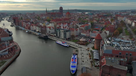 Aerial-view-of-drone-flying-forward-to-the-old-town-of-Gdansk,-Poland-above-the-Motlawa-river