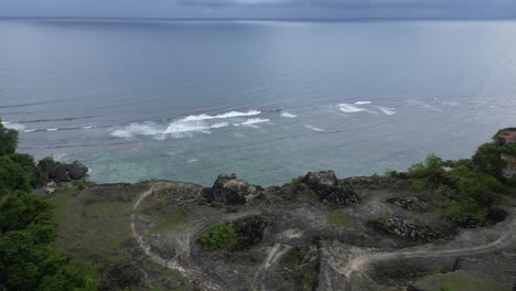 Aerial-shot-of-cliffs-leading-toward-the-sea-in-Uluwatu-in-the-south-of-Bali,-Indonesia