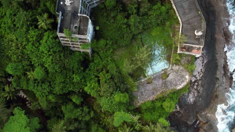 Bird-eye-drone-footage-passing-over-abundant-Berjaya-Mahe-beach-hotel-on-Mahe-island-near-the-coastline,-Mahe,-Seychelles-60-fps