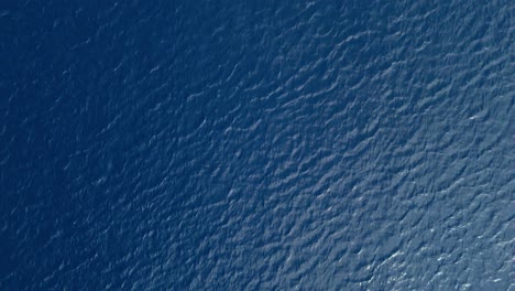 Top-down-drone-view-of-pulsing-currents-moving-across-ocean-sea-water-surface