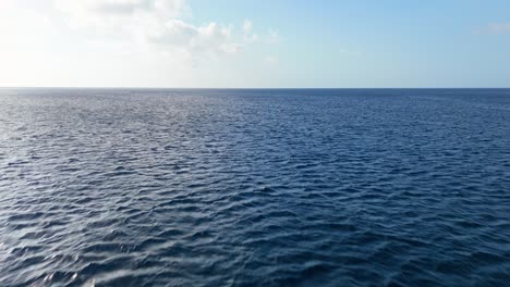 Aerial-dolly-forward-above-deep-vibrant-mysterious-blue-ocean-water-in-Caribbean