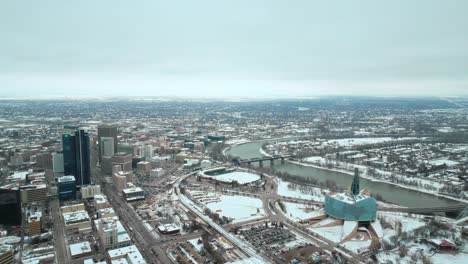 Establecimiento-De-Gran-Angular-Completo-Museo-Canadiense-De-Derechos-Humanos-Urbano-Winnipeg-Manitoba-Canadá-Centro-Rascacielos-Edificios-Ciudad-Nublado-Paisaje-Horizonte-Nevando-Invierno-Drone-4k-Tiro-Vista-Estática