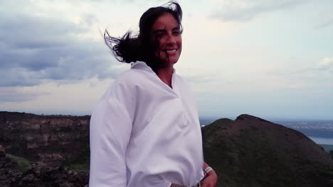 Hispanic-woman-enjoys-strong-breeze-at-volcano-summit-in-Nicaragua