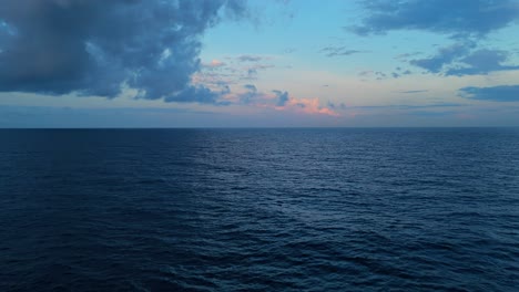 Blue-hour-after-sun-sets-above-dark-blue-Caribbean-ocean-water,-pastel-sky