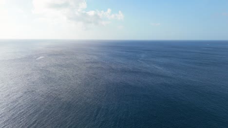 High-angle-overview-of-empty-ocean-sea-as-wind-blows-waves-across-surface,-view-to-horizon