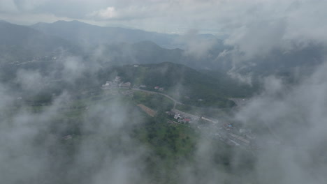 Aerial-view-overlooking-a-Shiga-Kogen-village-in-middle-of-clouds,-in-Japan,-Asia
