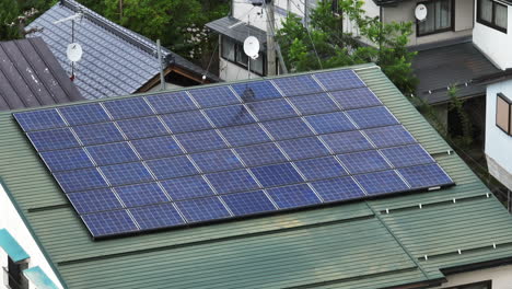 Drone-shot-around-of-solar-cells-on-a-japanese-house,-cloudy-day-in-Japan