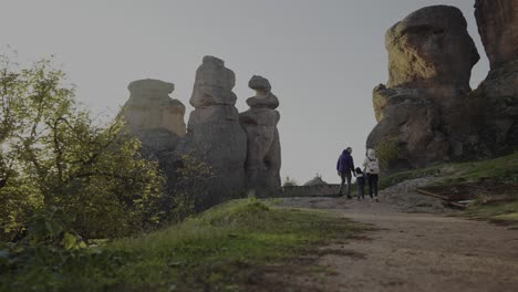 A-family-of-tourists-walking-towards-the-Belogradtchik-fortress-made-of-natural-rock-formations-located-in-the-province-of-Vidin,-in-Bulgaria
