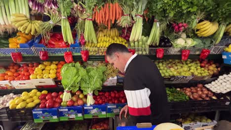 Person-is-arranging-fruits-and-vegetables-on-pristine-shelves,-embodying-a-commitment-to-offering-wholesome-choices-at-the-local-grocery-store