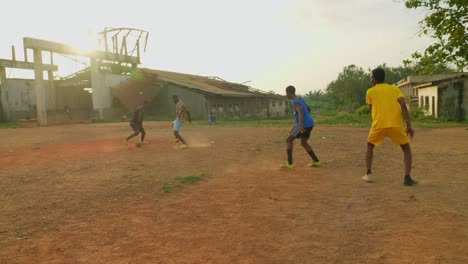 Der-Ball-Wird-Dem-Spieler-Mit-Dem-Gelben-Trikot-Zugespielt-Und-Dann-Zurückgespielt,-Während-Sie-Versuchen,-Durch-Die-Verteidiger-Hindurchzugehen.-Junge-Leute-Spielen-Auf-Einem-Gemeinschaftsfeld-In-Kumasi,-Ghana,-Fußball