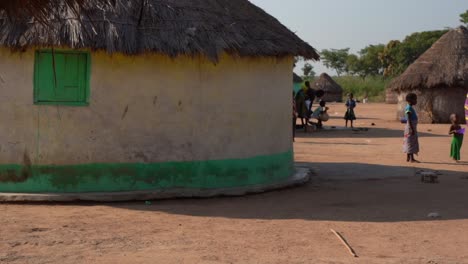 Cabaña-Y-Gente-De-La-Tribu-Rural-De-Ghana-Vistiendo-Telas-Coloridas-Tradicionales