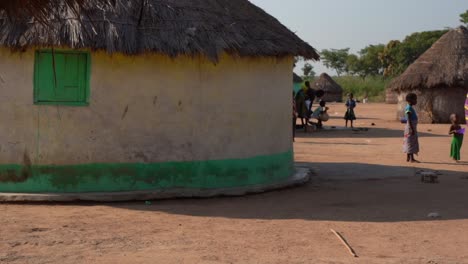 Hütte-Und-Menschen-Des-Ländlichen-Ghanaischen-Stammes-Tragen-Traditionelle-Bunte-Stoffe