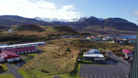 Drone-flying-over-Grundarfjordur-church-with-mountains-in-background,-Iceland