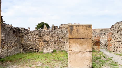 A-pathway-through-the-ruins-of-Pompeii,-lined-with-the-remains-of-walls-and-columns-that-once-formed-part-of-this-ancient-Roman-city